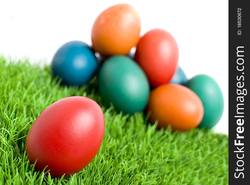 Colorful Easter eggs on green grass, with copy space