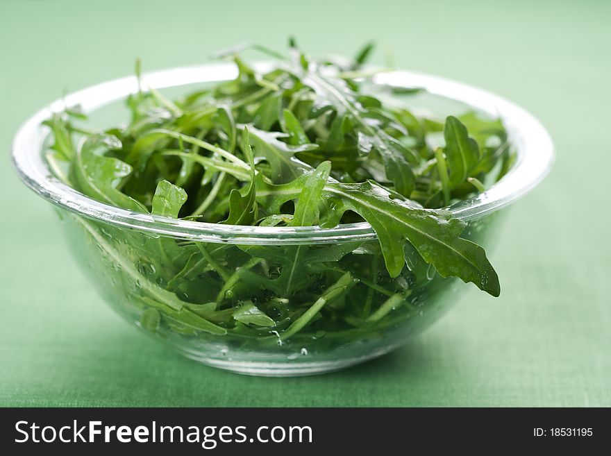 Green rucola fresh salad in glass bowl