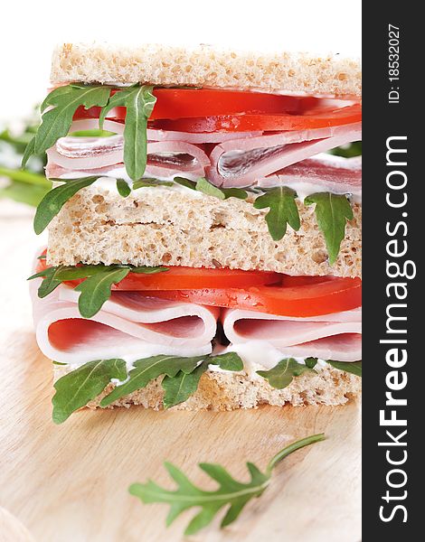Sandwich with ham,tomato, and rucola salad on white