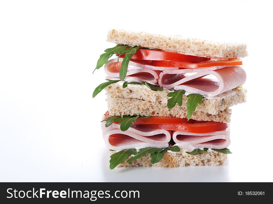 Sandwich with ham,tomato, and rucola salad on white