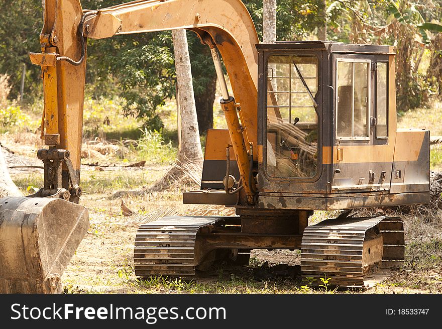 Construction digger in the jungle clearing land for development. Construction digger in the jungle clearing land for development