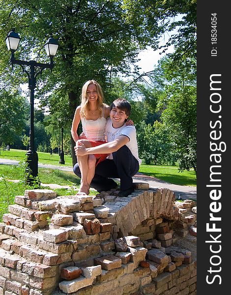 Sitting in the ruins of ancient brick walls of a young couple happily laughing. Sitting in the ruins of ancient brick walls of a young couple happily laughing