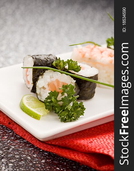 Photo of delicious sushi and sashimi food on rectangular plate with parley