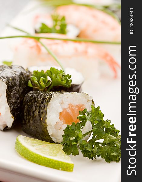 Photo of delicious sushi and sashimi food on rectangular plate with parley