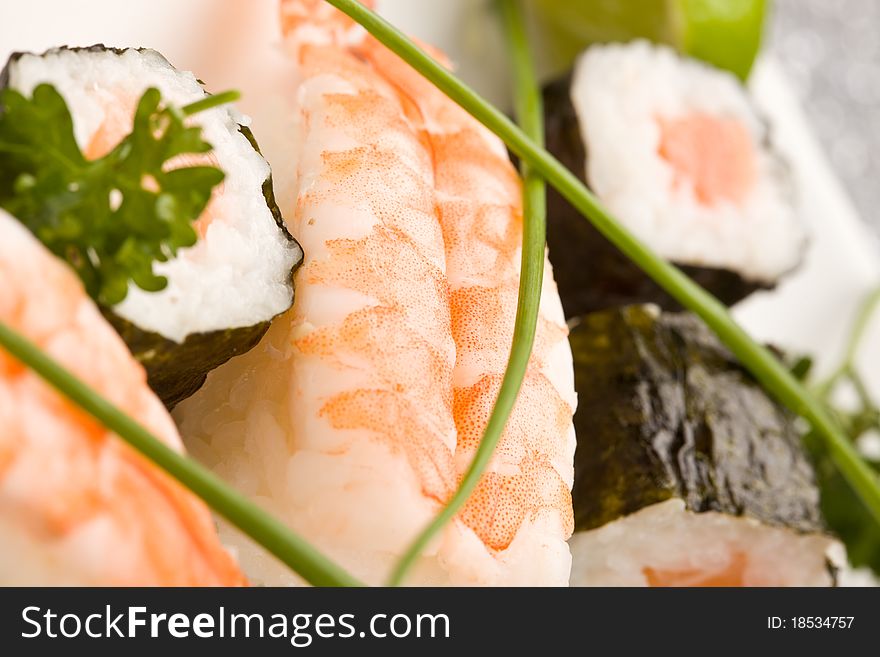 Photo of delicious sushi and sashimi food on rectangular plate with parley