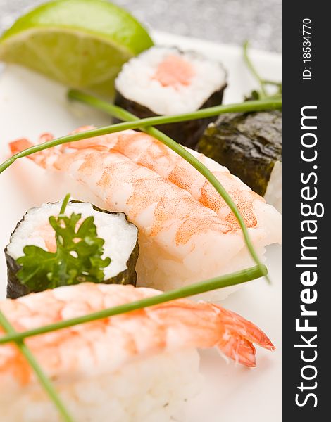 Photo of delicious sushi and sashimi food on rectangular plate with parley