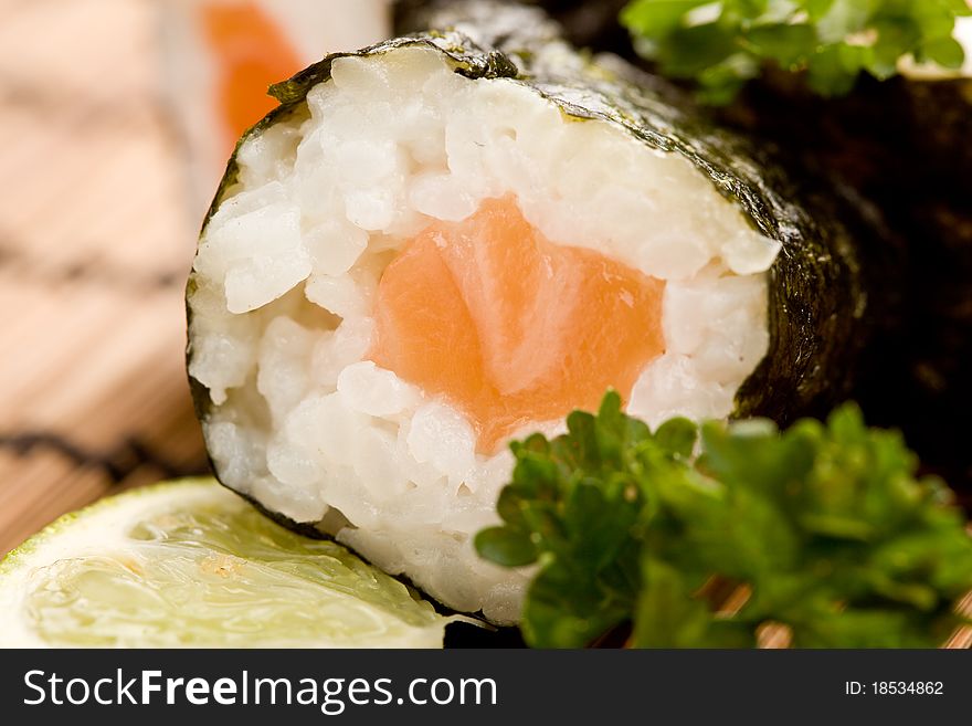 Photo of delicious sushi and sashimi food on rectangular plate with parley