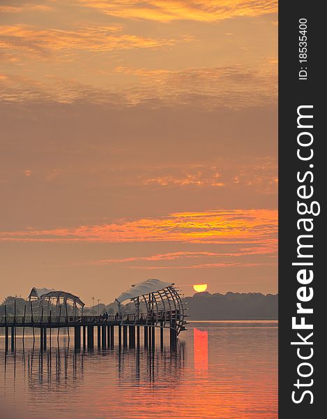 Dawn breaking from behind a uniquely shaped pier. Dawn breaking from behind a uniquely shaped pier