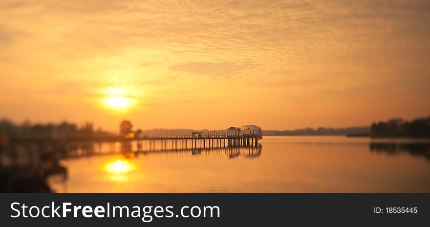 Dawn breaking from behind a uniquely shaped pier taken with a tilt shift lens to replicate a miniature architectural model. Dawn breaking from behind a uniquely shaped pier taken with a tilt shift lens to replicate a miniature architectural model