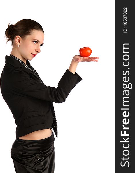Girl in black suit looks at tomato in her hand. Isolated on white. Girl in black suit looks at tomato in her hand. Isolated on white.
