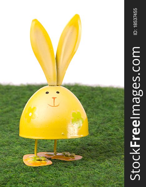 Yellow egg-shaped rabbit staying on green grass. Yellow egg-shaped rabbit staying on green grass