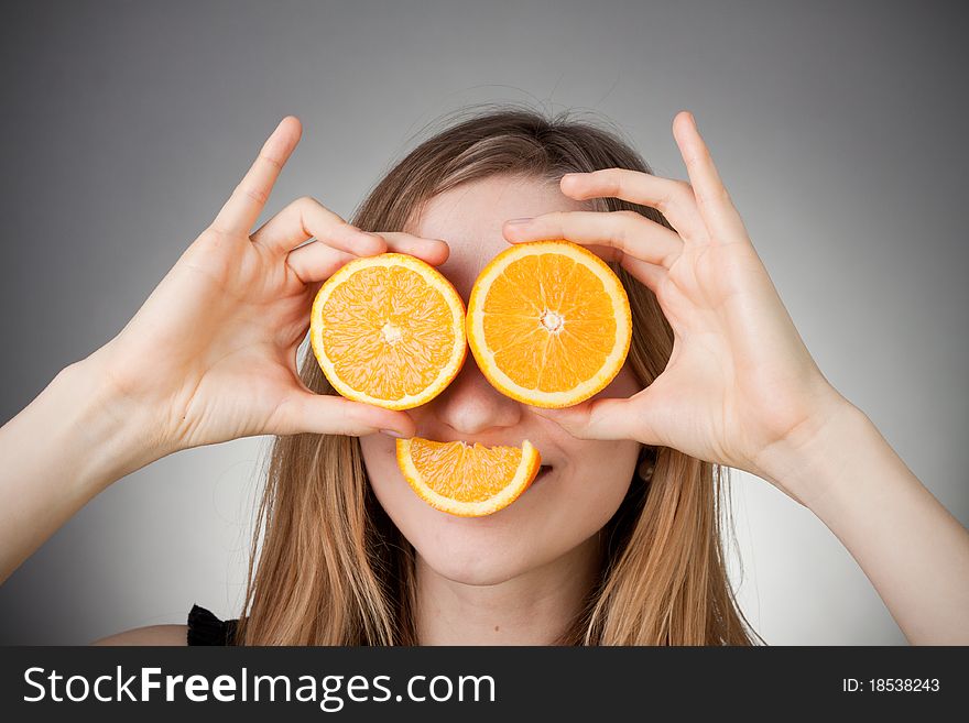Girl Using Orange As Eyes, With Grey Background