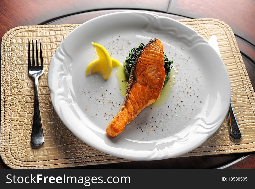 Grilled fish with salad and sauce on a plate