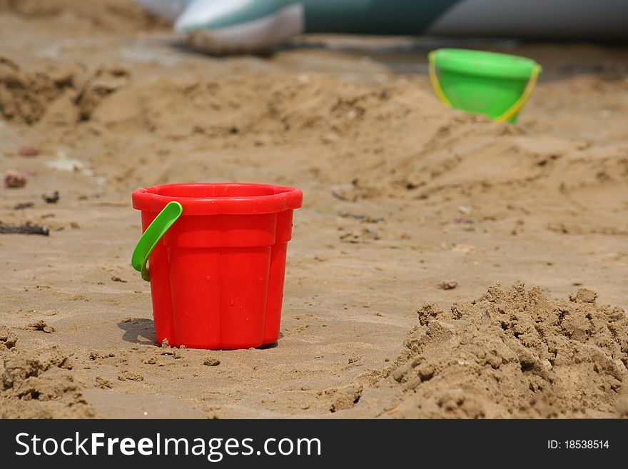 Red bucket on sand close-up