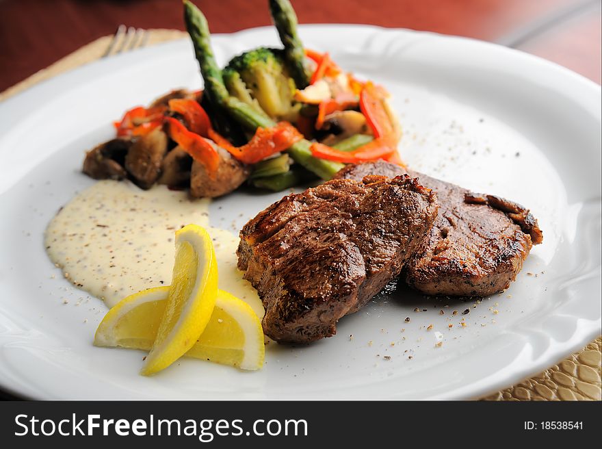 Grilled meat with sauce and vegetables on the plate