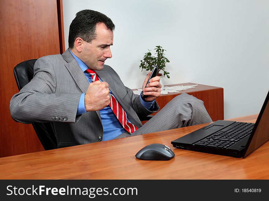 Angry businessman in his office talking on the phone.