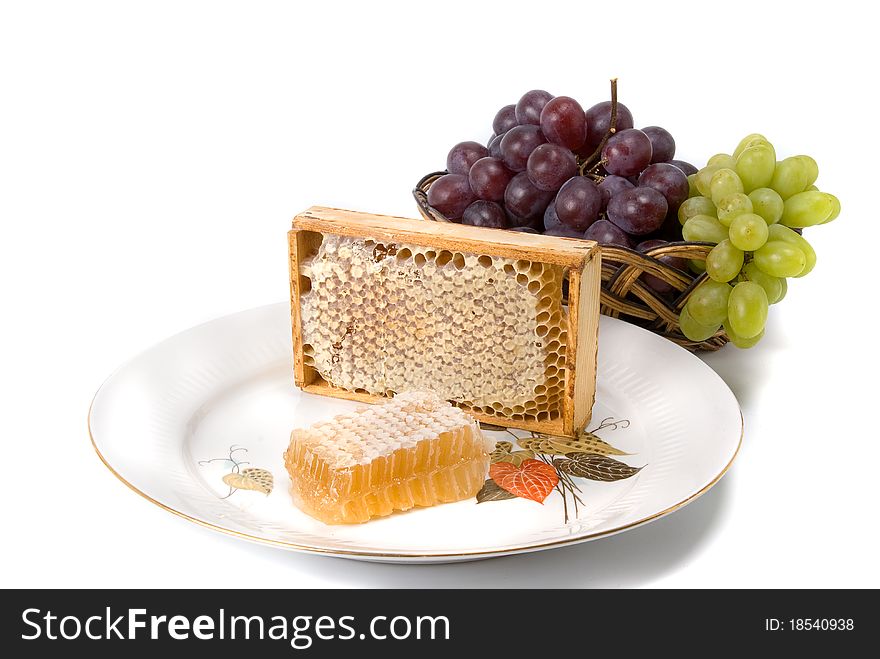 Honeycomb in border with grapes on dish