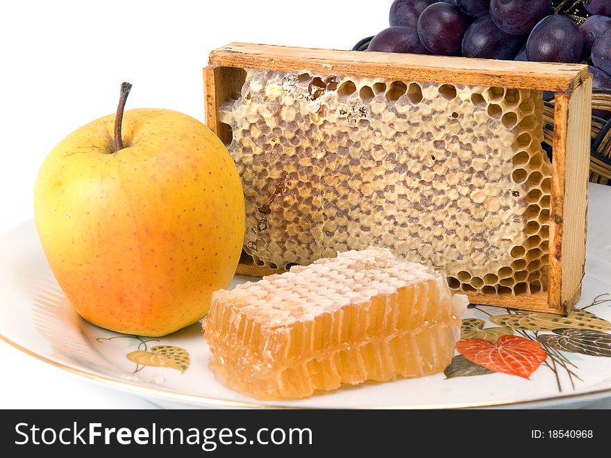 Honeycomb in border with fruits on dish