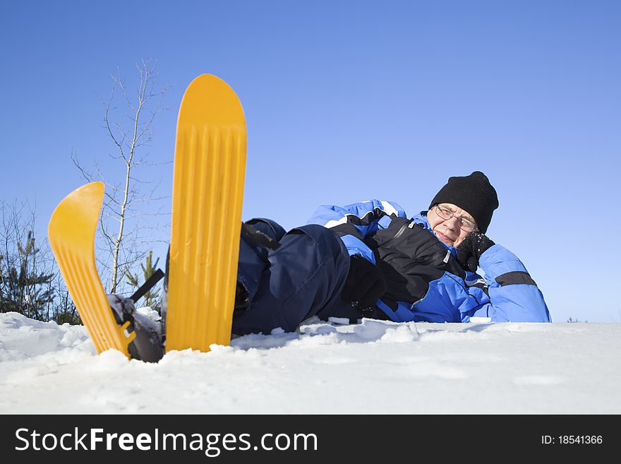 Middle-aged man lying in snow. Finnish countryside.