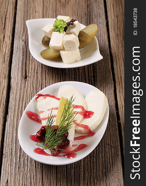 Slices of mozzarella and cubes of marinated feta cheese. Slices of mozzarella and cubes of marinated feta cheese