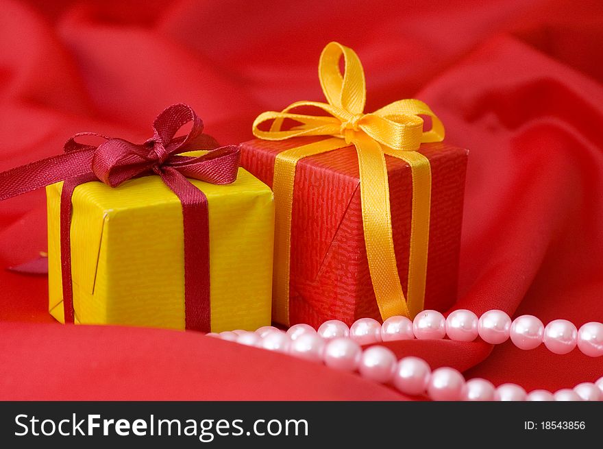 Box with a gift on a red fabric still life