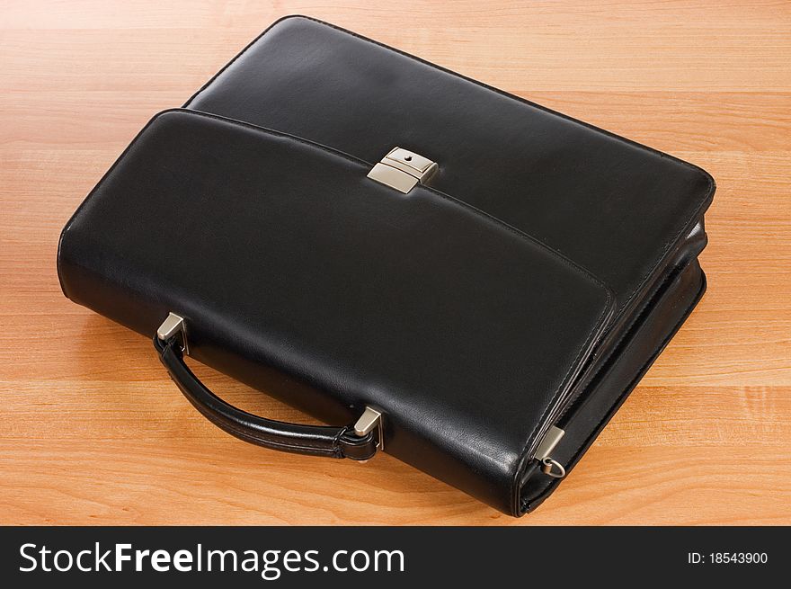 Fashionable leather briefcase on a table close up