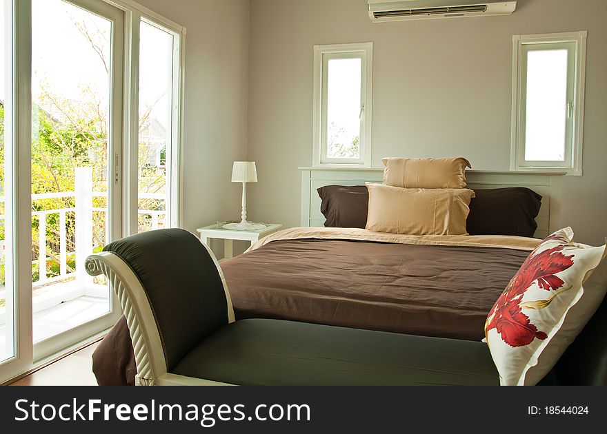 White Bedroom With Brown Sheet Bed And Couch