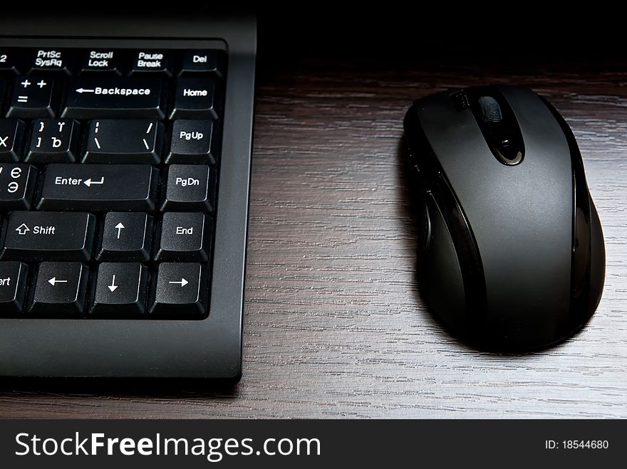 Black keyboard and mouse on a desk. Black keyboard and mouse on a desk.