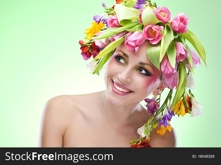 Beauty woman portrait with wreath from flowers on head green background