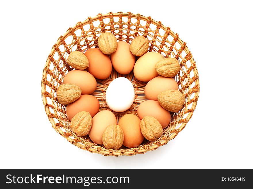 Eggs with nuts in the basket isolated on white