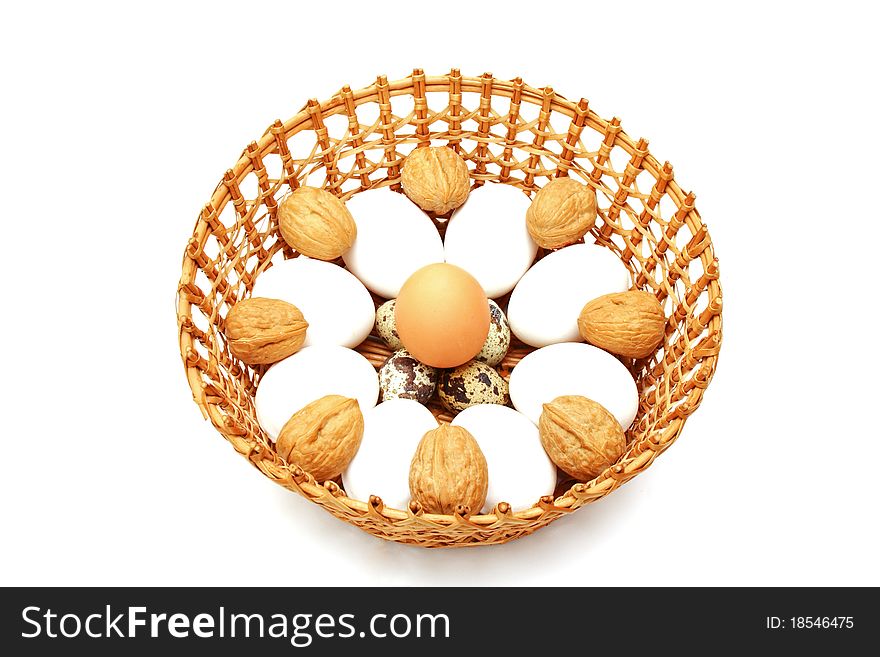 Eggs and quail egg in the basket isolated. Eggs and quail egg in the basket isolated