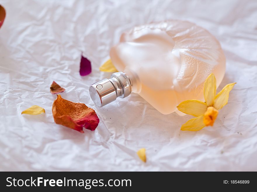 Perfume with dry petal on crumpled paper