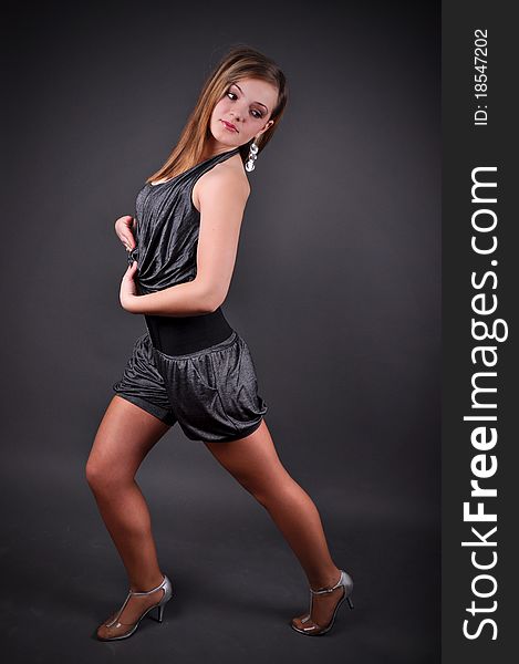 Modern dancer poses in front of the gray background