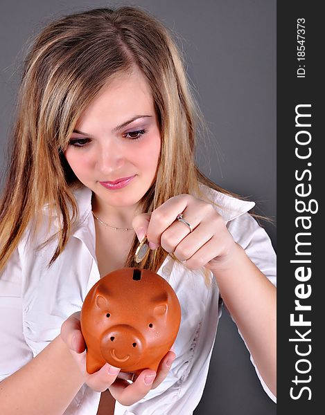 Woman putting coin in piggy bank