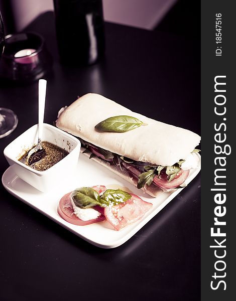 Long baguette sandwich with ham,  fresh vegetables and pesto. Long baguette sandwich with ham,  fresh vegetables and pesto