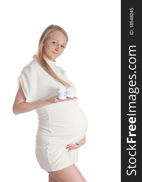 Pregnant young woman, holding baby's bootees. Pregnant young woman, holding baby's bootees.