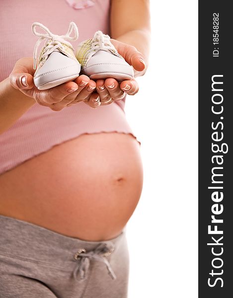 Pregnant woman holding pair of white shoes for baby (Shallow dof). Pregnant woman holding pair of white shoes for baby (Shallow dof)