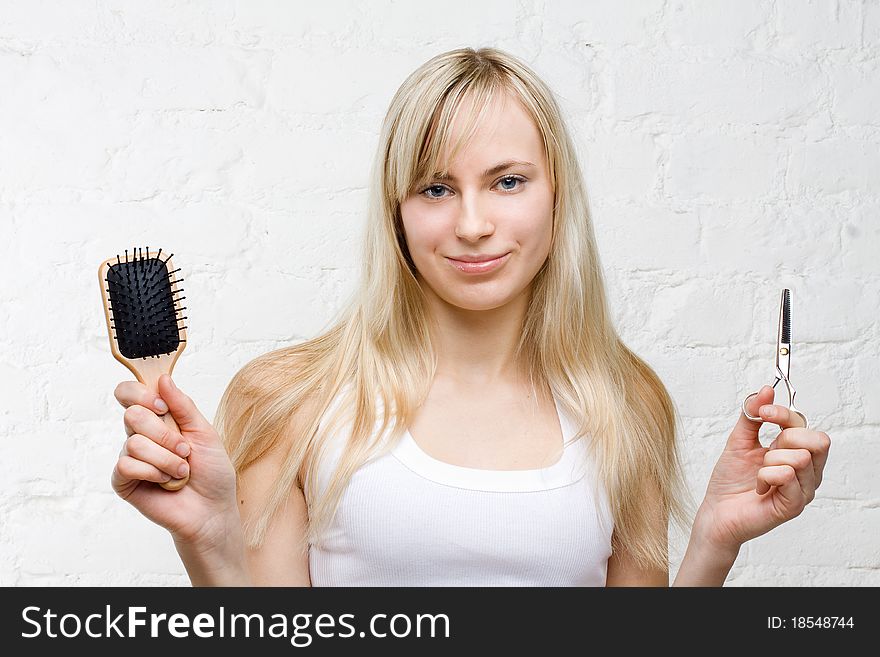 Smiling woman holding comb and scissors