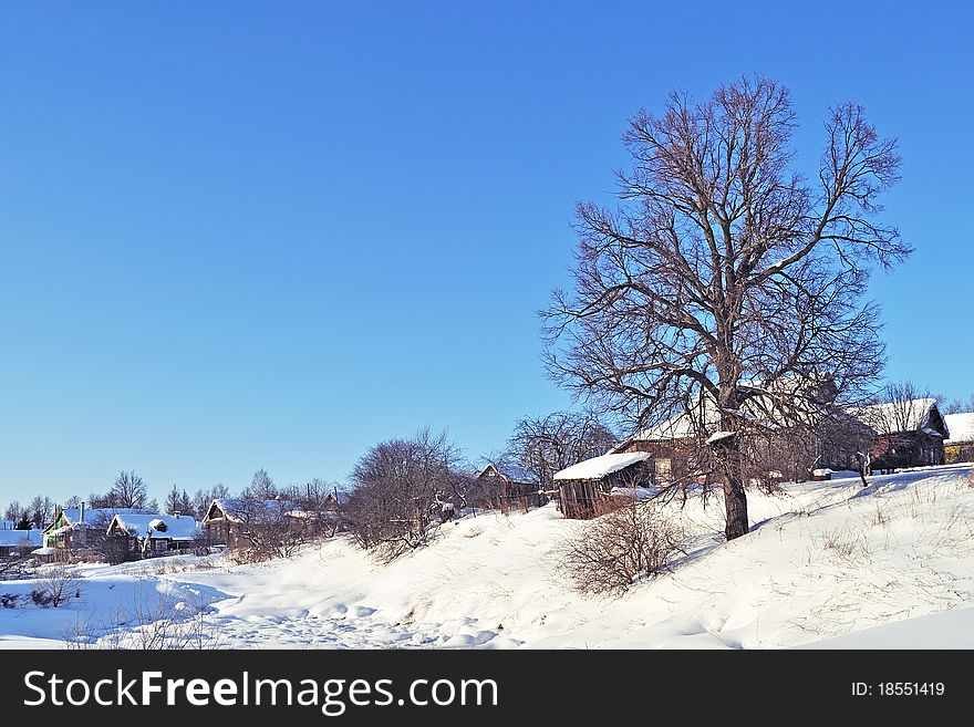 Old wooden houses and big tree on the hill in winter time, Russia. Old wooden houses and big tree on the hill in winter time, Russia