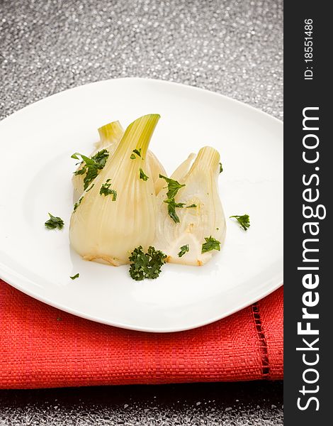 Photo of cooked fennel with parley on a glass table