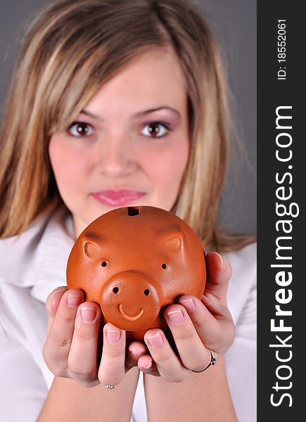 Smiling female holding piggy-bank