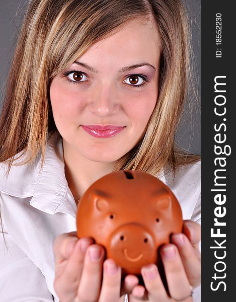 Smiling female holding piggy-bank
