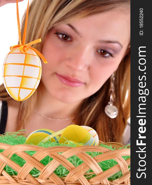 Young beautiful girl with basket and easter eggs in her hand