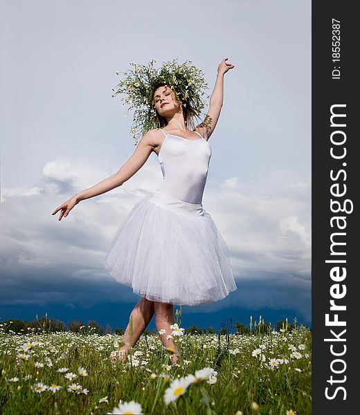 Young beautiful ballet dancer against cloudy sky