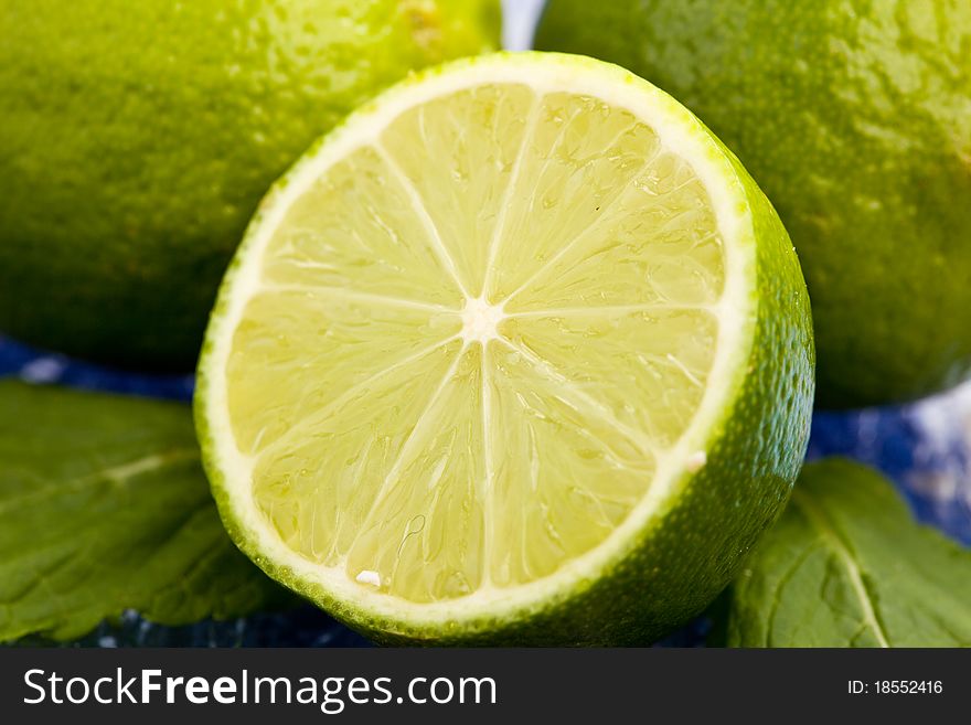 Photo of fresh lime on mint leaf putted on a blue glass table