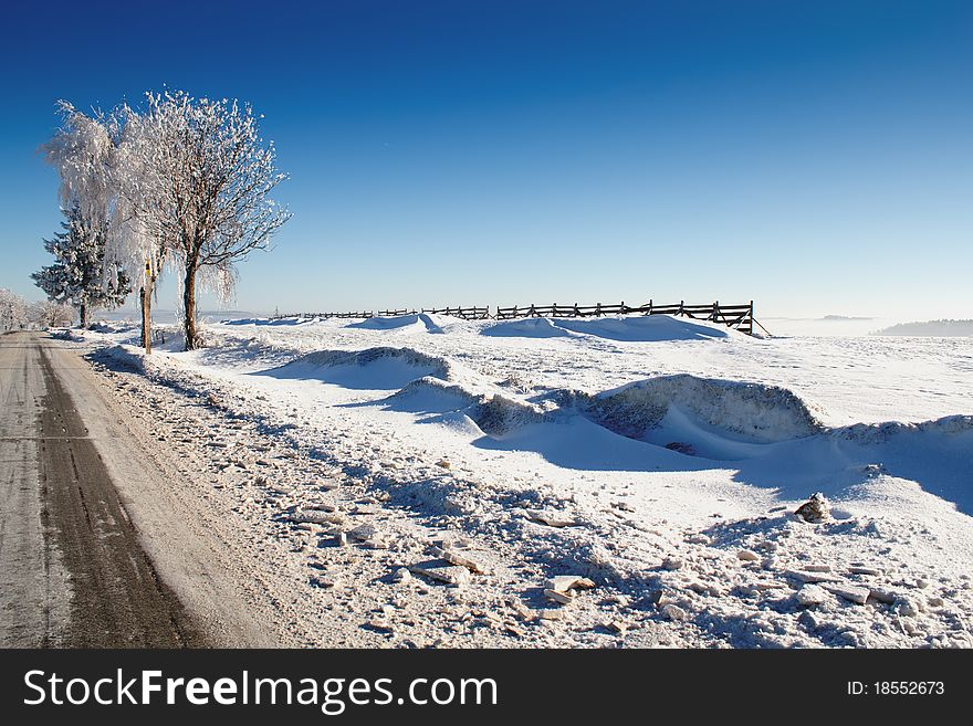 Winter road on a sunny frosty day with blue sky