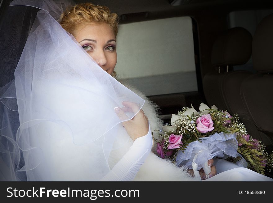 Pretty bride in a car window