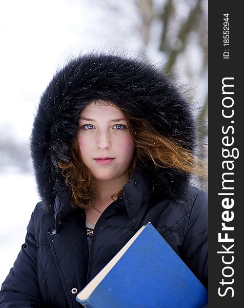 Young girl in the hood with blue book