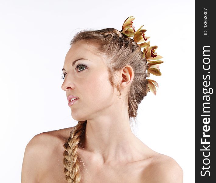 Portrait of the beauty young blond girl with orchid in her hair