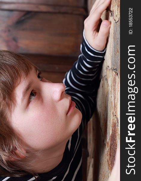 A teenager leaning against the stone wall. A teenager leaning against the stone wall.